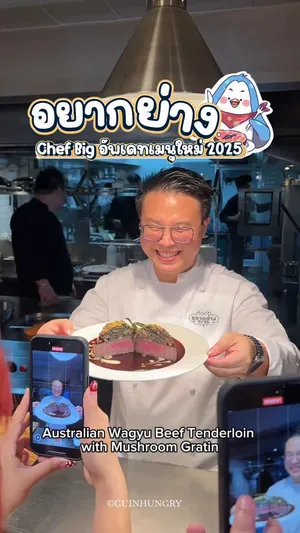 ภาพสเต๊กเนื้อฟิเลย์มิญองวากิวออสเตรเลียจากร้านอยากย่าง (Yak Yang) ซึ่งเป็นเมนูชนะเลิศของเชฟบิ๊ก อรรถสิทธิ์ จาก Top Chef Thailand 2023 เนื้อสเต๊กหั่นเป็นชิ้นหนา สีชมพูอมแดงน่ารับประทาน วางเรียงบนจานสีขาวสวยงาม ด้านบนท็อปด้วยกราแตงเห็ดสีครีม และราดด้วยซอสไวน์แดงเข้มข้นที่วาดเป็นลวดลายประณีตคล้ายลาเต้อาร์ต ตกแต่งด้วยสมุนไพรสีเขียว มีข้อความซ้อนทับบนภาพเป็นภาษาไทยและอังกฤษว่า 'อยากย่าง Menu Top Chef yak_yang'